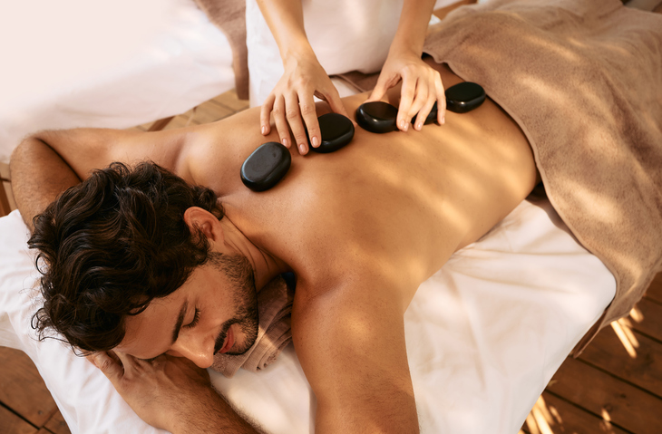 Man receiving hot stone back massage