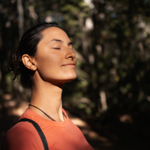 Woman basking in sunlight in forest