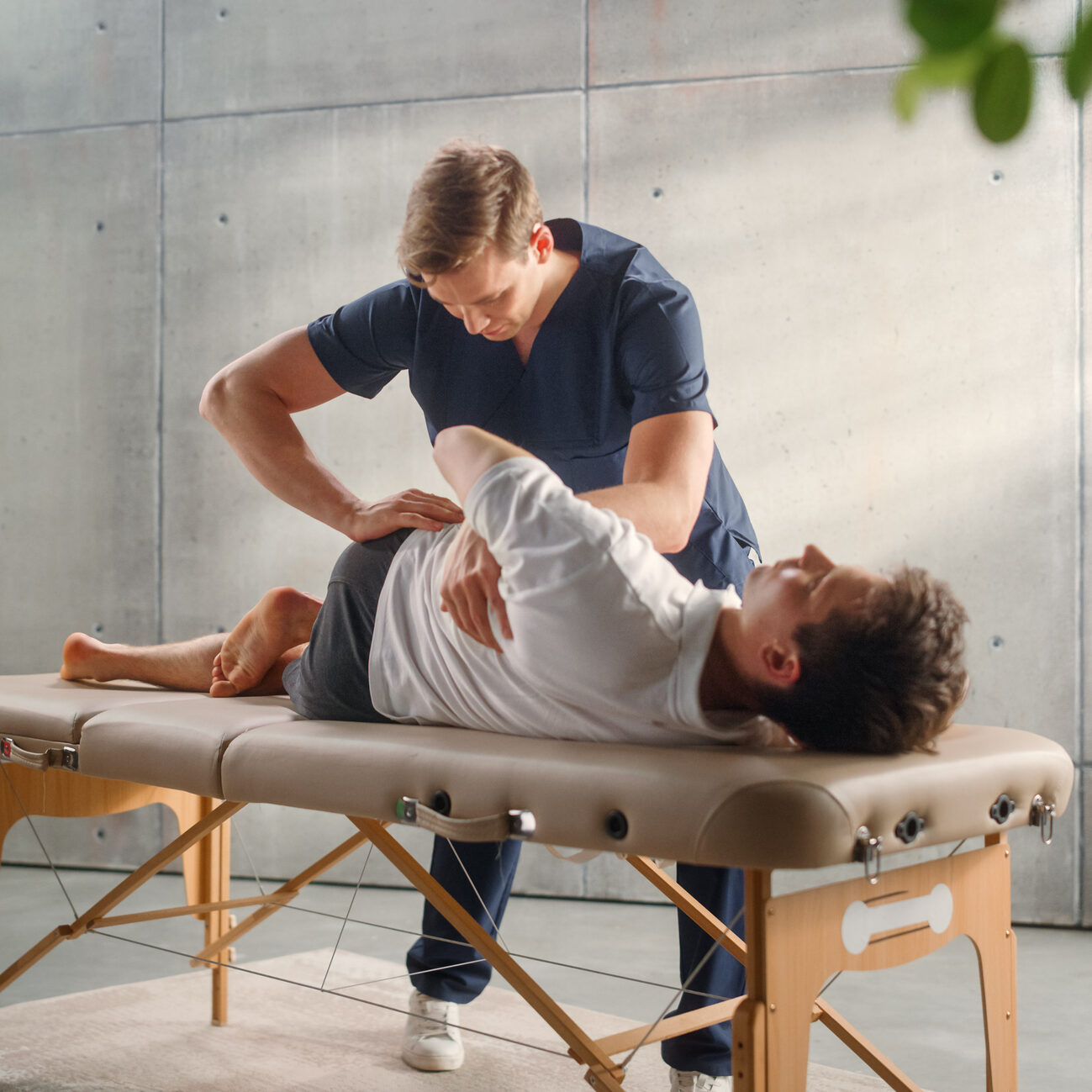 Physical therapist adjusting patient on treatment table