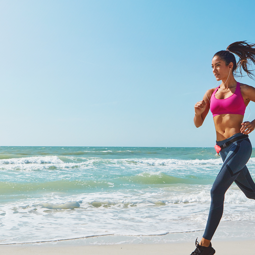 Fit woman running on sandy ocean beach